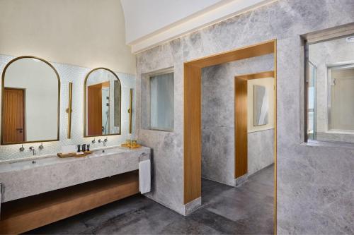 a bathroom with two sinks and two mirrors at Sheraton Miramar Resort El Gouna in Hurghada