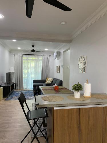 uma cozinha e sala de estar com um bar e um sofá em Homestay Hana Senawang em Seremban