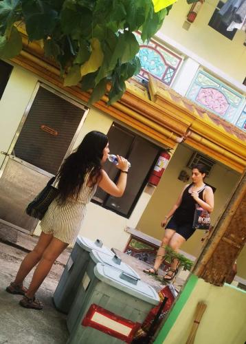 a woman standing in front of a mirror brushing her teeth at Bambooze Hauz in Boracay