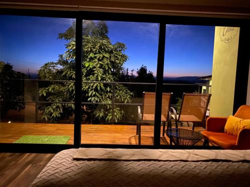a bedroom with a large glass window with a view at Palta 60 Valle de Guadalupe in Valle de Guadalupe