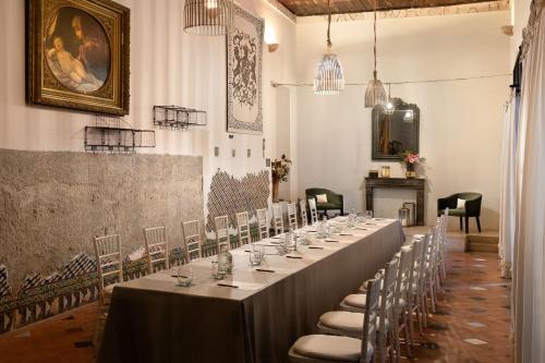 セビリアにあるLos Seises Sevilla, a Tribute Portfolio Hotelのテーブルと椅子付きの部屋内の長テーブル