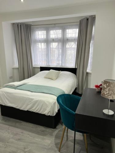a bedroom with a bed and a desk and a window at Starlet Property in Wanstead