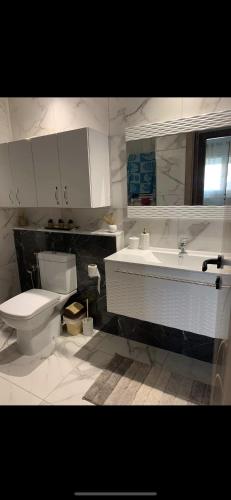 a bathroom with a toilet and a sink at Appartement Résidence Palm Lake Monastir in Monastir