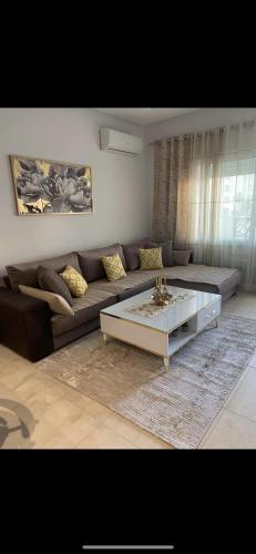 a living room with a couch and a coffee table at Appartement Résidence Palm Lake Monastir in Monastir