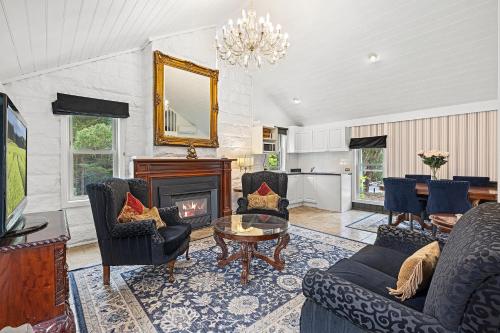 a living room with a fireplace and a table and chairs at A Loft In The Mill Boutique Accommodation in Olinda