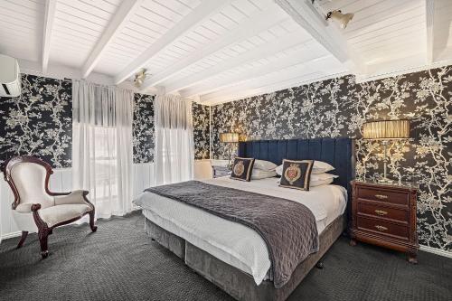 オリンダにあるA Loft In The Mill Boutique Accommodationのベッドと椅子のある寝室