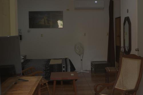 a living room with a bed and a table at La Casa del Chac in Mérida