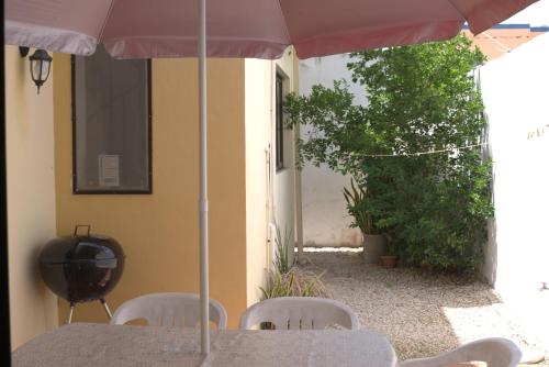 a table and chairs with an umbrella on a patio at La Casa del Chac in Mérida