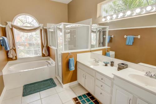 uma casa de banho com 2 lavatórios, uma banheira e um chuveiro em Rons Highlands Reserve Vacation Home em Davenport