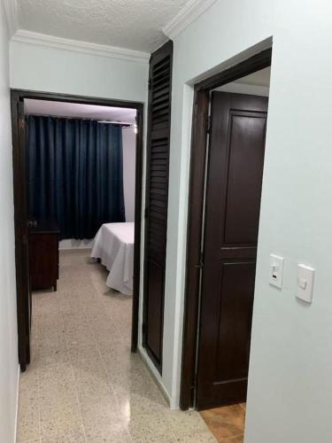 una camera con una camera da letto e una porta con un letto di Apartamento bien equipado en el centro de la ciudad a Santo Domingo