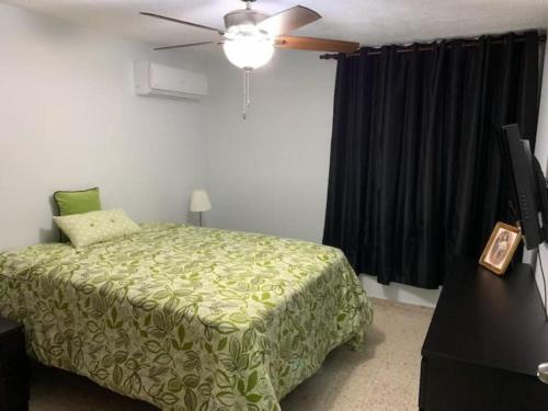 una camera con letto e ventilatore a soffitto di Apartamento bien equipado en el centro de la ciudad a Santo Domingo
