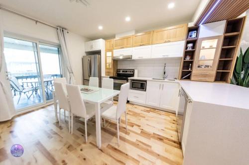 a kitchen with a table and chairs in a room at Le Petit Manoir - Quartz in Lac-Simon