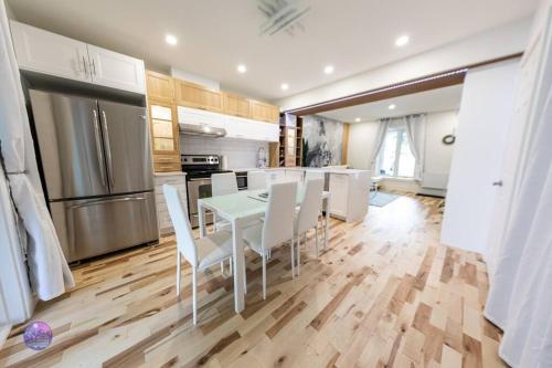 a kitchen with a white table and white chairs at Le Petit Manoir - Quartz in Lac-Simon