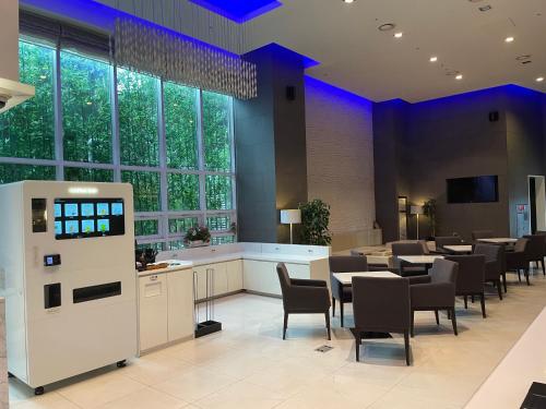 a dining room with tables and chairs and windows at Uljiro Coop Residence Dongdaemun in Seoul