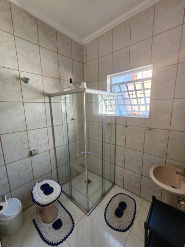 a bathroom with a shower with a toilet and a sink at Ampla Casa em Aparecida in Aparecida