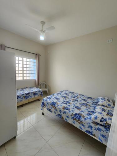 a bedroom with two beds and a window at Ampla Casa em Aparecida in Aparecida