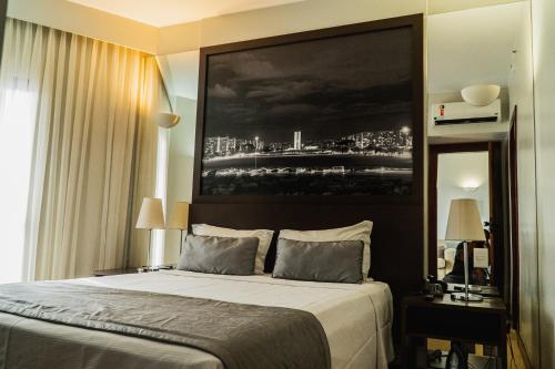 a bedroom with a bed with a large painting above it at Bonaparte - Excelente Apartamento #1416 in Brasilia