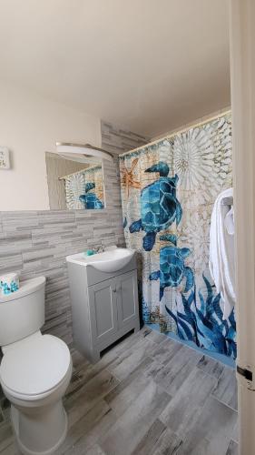 La salle de bains est pourvue de toilettes et d'un mur en mosaïque. dans l'établissement Conca D'or Motel, à Wildwood Crest