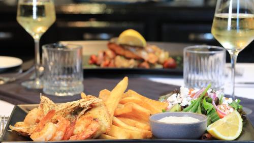 a plate of food with fish and chips on a table at Hilltop Motel in Broken Hill