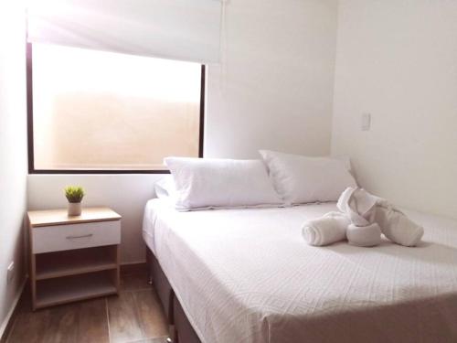 a bedroom with a bed with a stuffed animal on it at Apartamento en Medellín-clínica las Americas in Medellín