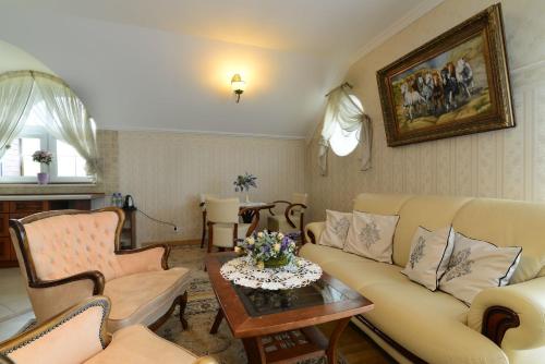 a living room with a couch and chairs and a table at Villa Tropikana in Łeba