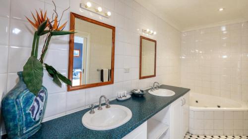 a bathroom with two sinks and a vase at Hilltop Motel in Broken Hill