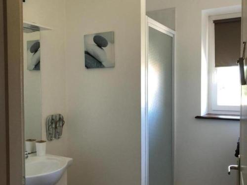 Baño blanco con lavabo y espejo en Gîte Le Bouchaud, 5 pièces, 8 personnes - FR-1-489-227, en Le Bouchaud