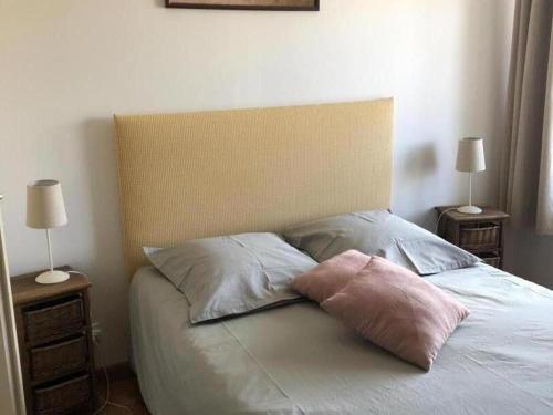 a bed with two pillows on it with two lamps at Maison champêtre rénovée avec cheminée, terrasse et jardin - Idéale pour familles et amis - FR-1-489-227 in Le Bouchaud