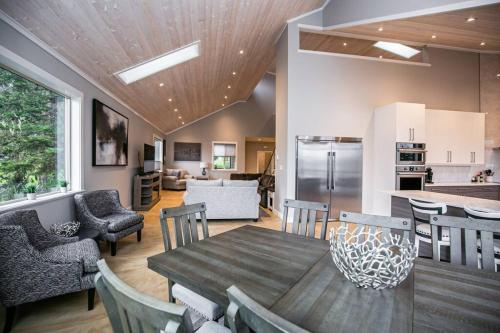 a kitchen and living room with a wooden table and chairs at Water Front Home with Private Dock and Hottub in Sooke