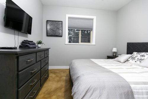 a bedroom with a bed and a television on a dresser at Water Front Home with Private Dock and Hottub in Sooke