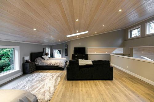 a bedroom with a bed and a couch in a room at Water Front Home with Private Dock and Hottub in Sooke