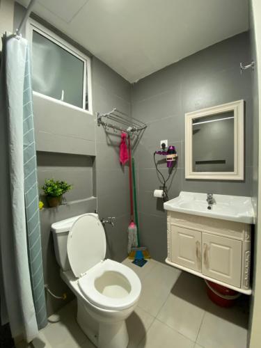 a bathroom with a toilet and a sink at A Modern & Homely Studio with Pool and Gym in Kampar