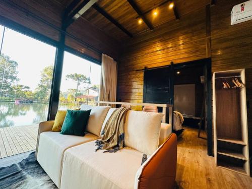 ウルビシにあるChalé Victoria- Pousada Cachoeira da Neveのソファと大きな窓のあるリビングルーム