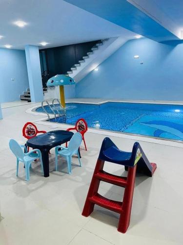 una piscina con mesa y sillas junto a una piscina en villa wardet algabal en Jericho