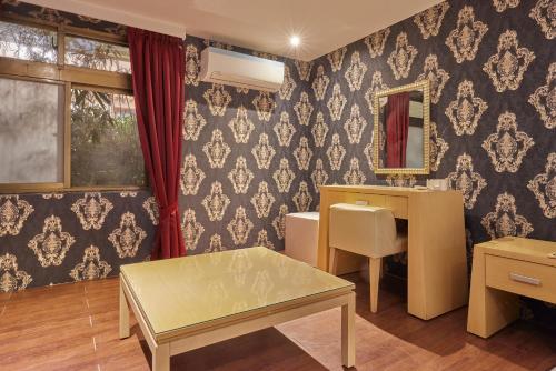 Kyokusui Hotspring Hotel في تايبيه: غرفة ملابس مع طاولة ومرآة