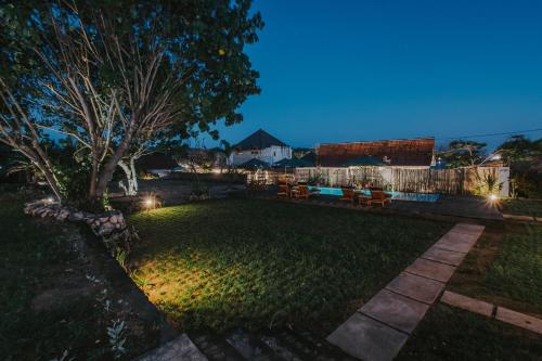 a backyard at night with lights on the grass at Paluh Beach Huts in Nusa Lembongan