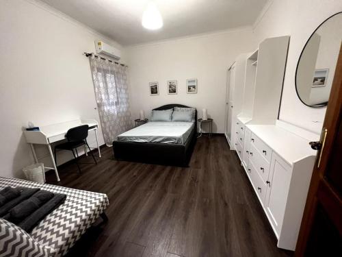 a bedroom with a bed and a desk with a mirror at Spacious, Central 3BR Apartment with Backyard in Is-Swieqi