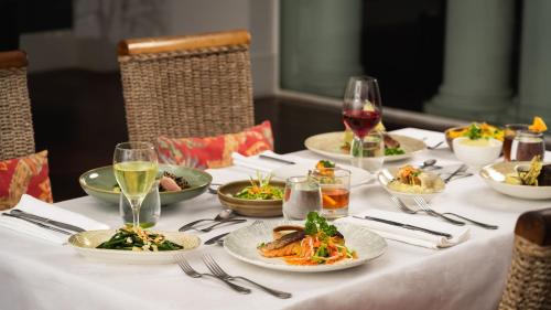 a table with plates of food and glasses of wine at Grand Pacific Hotel in Suva