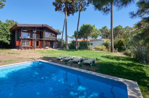 a swimming pool in front of a house with palm trees at Beach & Golf Retreat w Amazing pool, By TimeCooler in Aroeira
