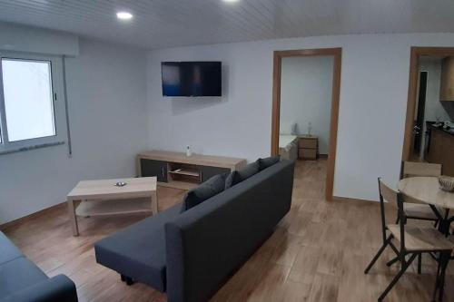 een woonkamer met een bank en een tafel bij Villa T2 Maçussa - 45min Lisbon in Massuça