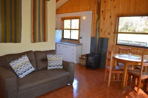 a living room with a couch and a table at Cabañas Valle del Río in Curacautín
