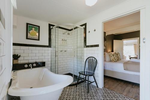 a bathroom with a white tub and a bedroom at The Cooks House at Corunna Station in Belford