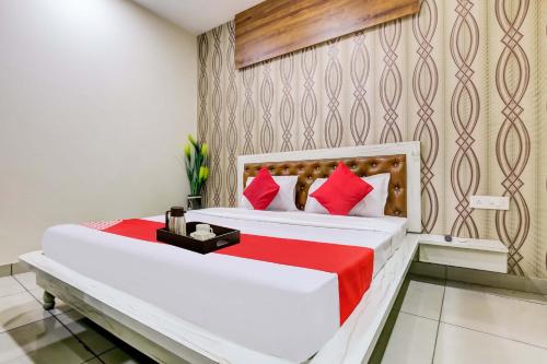 a bedroom with two beds with red pillows at Super OYO Flagship Hotel Sky Land in Ludhiana