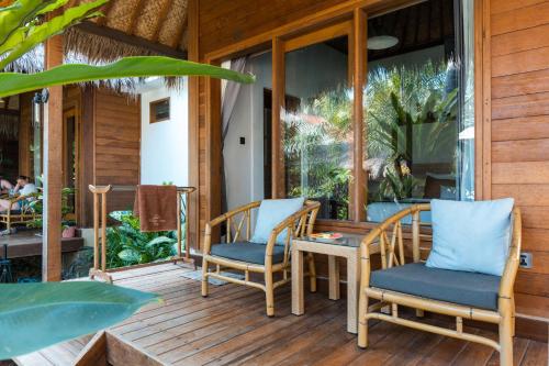 a patio with two chairs and a table on a porch at Village Vibes Lombok in Kuta Lombok