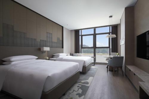 a hotel room with two beds and a desk at Wenzhou Marriott Hotel in Wenzhou