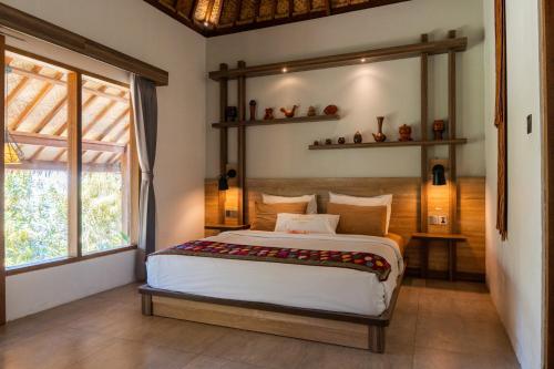 - une chambre avec un lit et une grande fenêtre dans l'établissement Village Vibes Lombok, à Kuta Lombok