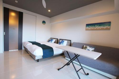 a bedroom with a bed and a table in it at Maedamisaki Grand Blue 103 in Onna