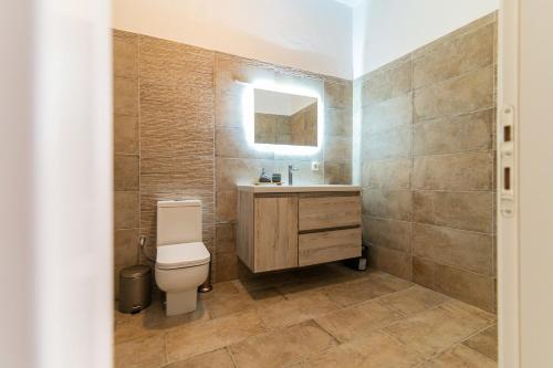a bathroom with a toilet and a sink and a mirror at Costa Mare in Paralia Vrachou