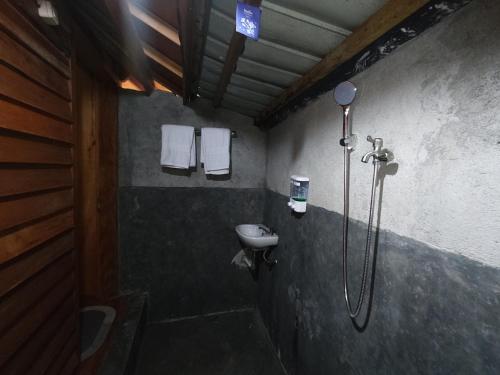 a bathroom with a shower with a sink and a toilet at Pondok Elen Mandalika in Praya