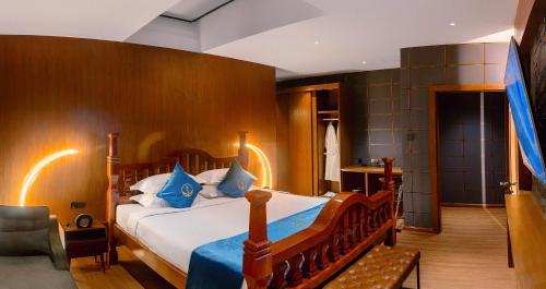 a bedroom with a large bed with blue pillows at The Waiting Lodge in Pyin Oo Lwin